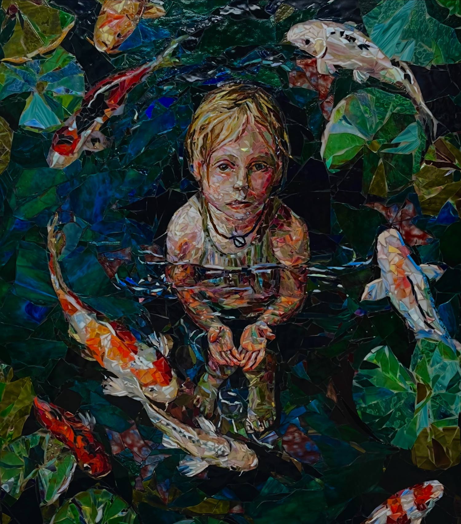 Child with short blonde hair in water surrounded by koi fish and green lily pads, holding hands together.