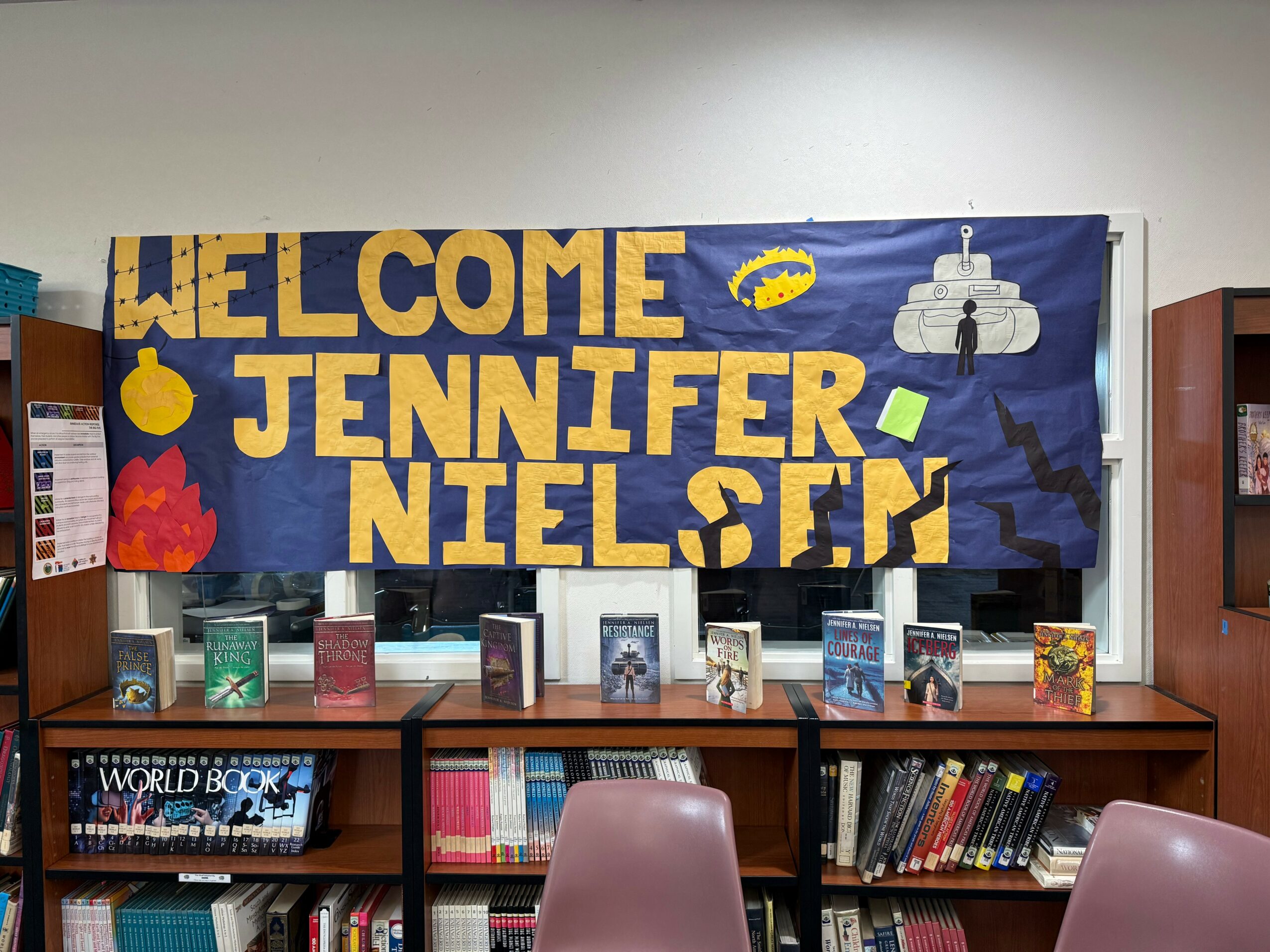 Colorful welcome banner with text and space-themed decorations, displayed above a bookshelf in a room.