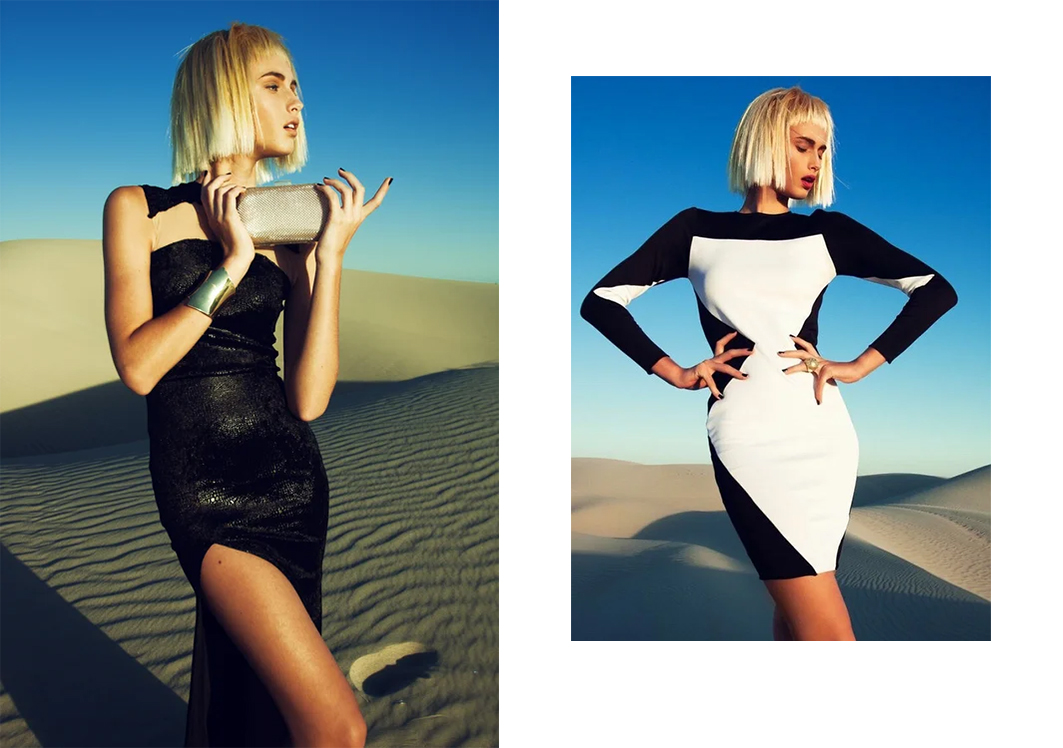 Two women in desert landscape, one in black dress, the other in black and white dress, both with blonde hair.