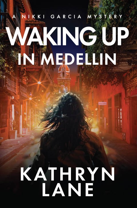 Person with long hair standing on a city street at sunset, buildings illuminated, with text about Medellin and author Kathryn Lane.