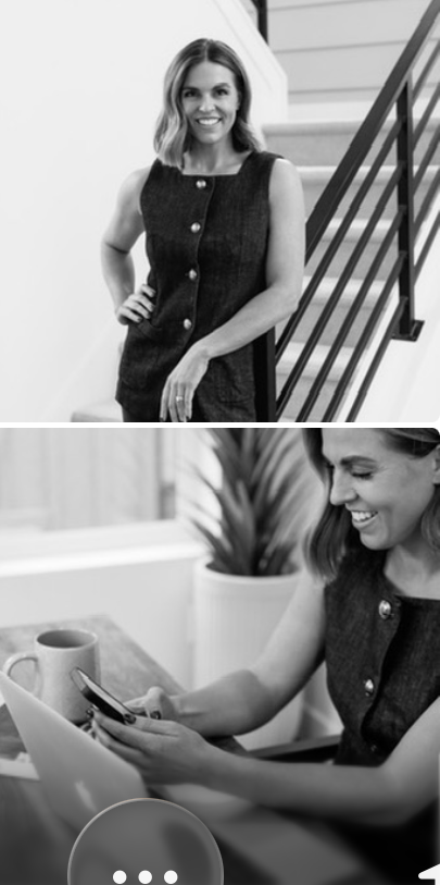 Woman smiling, standing near staircase, wearing sleeveless dress, hand on hip, in black and white.