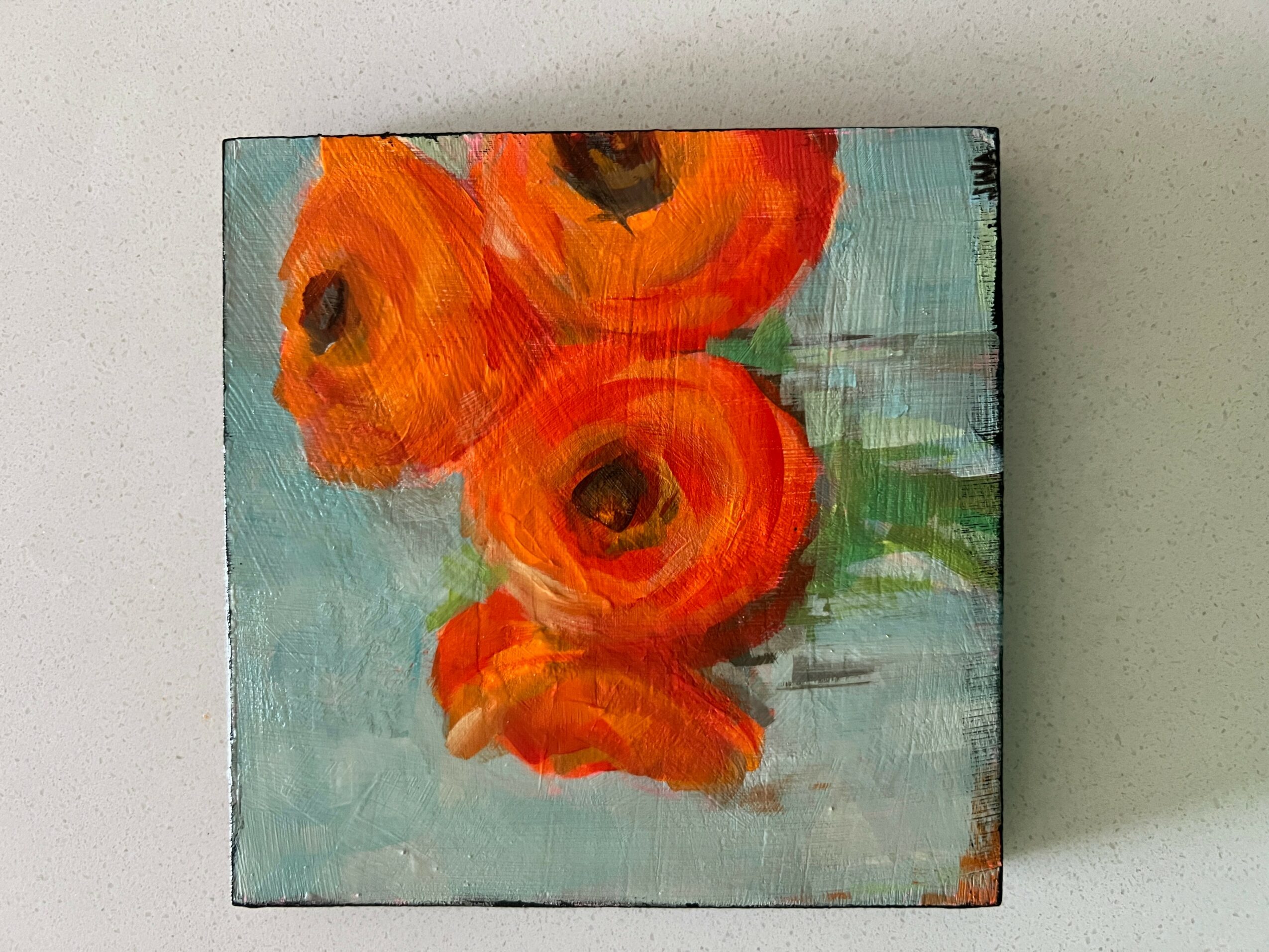 Painting of orange flowers with green leaves on a light blue background, viewed sideways.