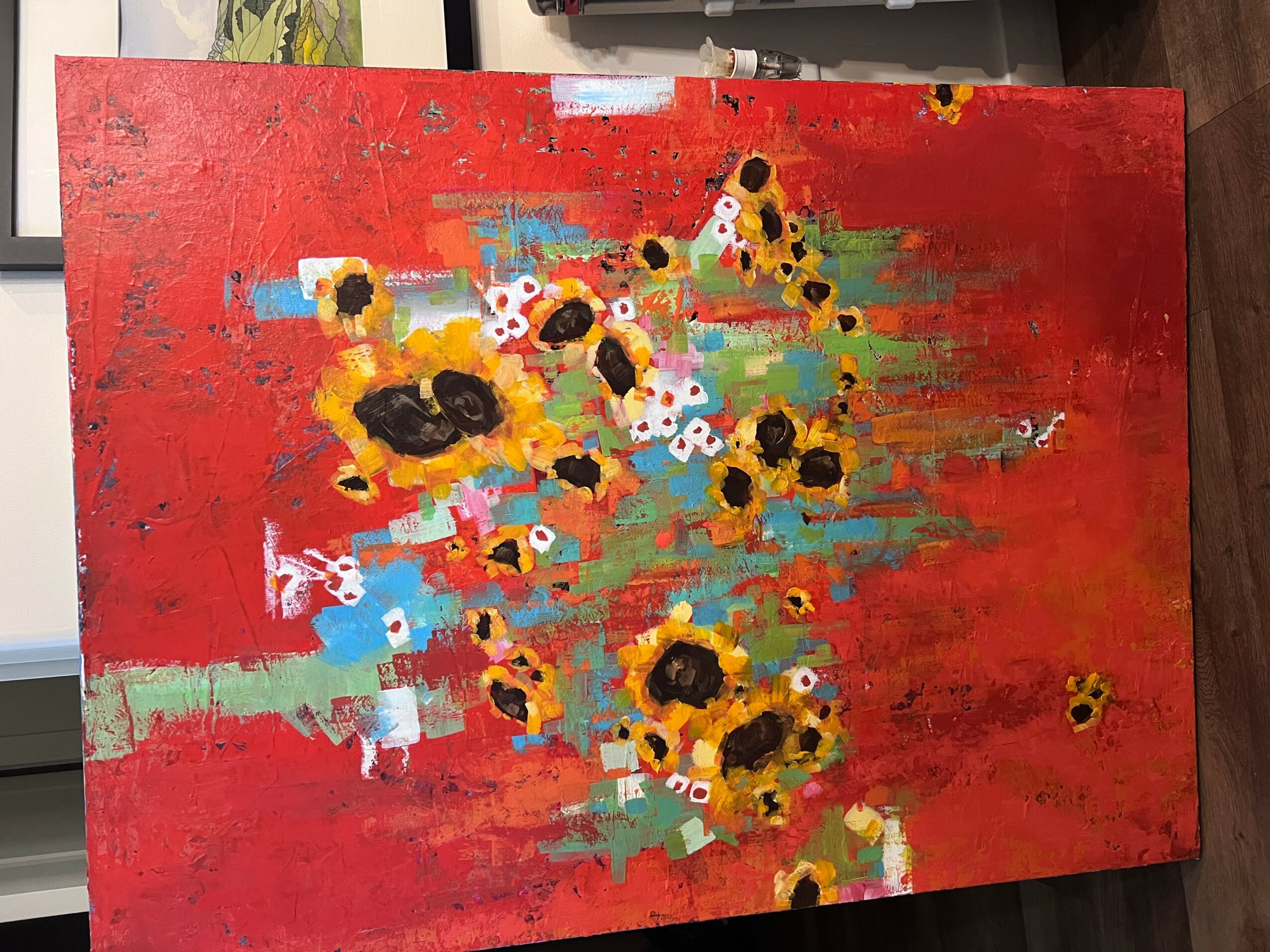 Abstract painting with yellow, black, white, and red flowers on a red background.