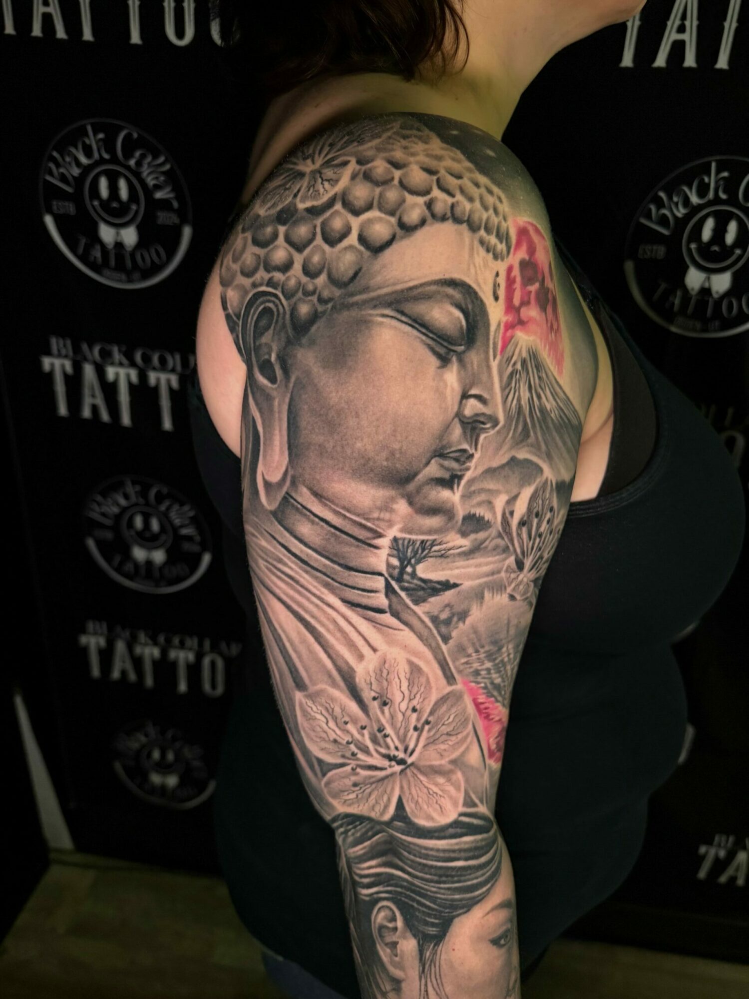 Tattooed arm with detailed portrait of a woman, floral elements, and geometric patterns, displayed on a person's arm.