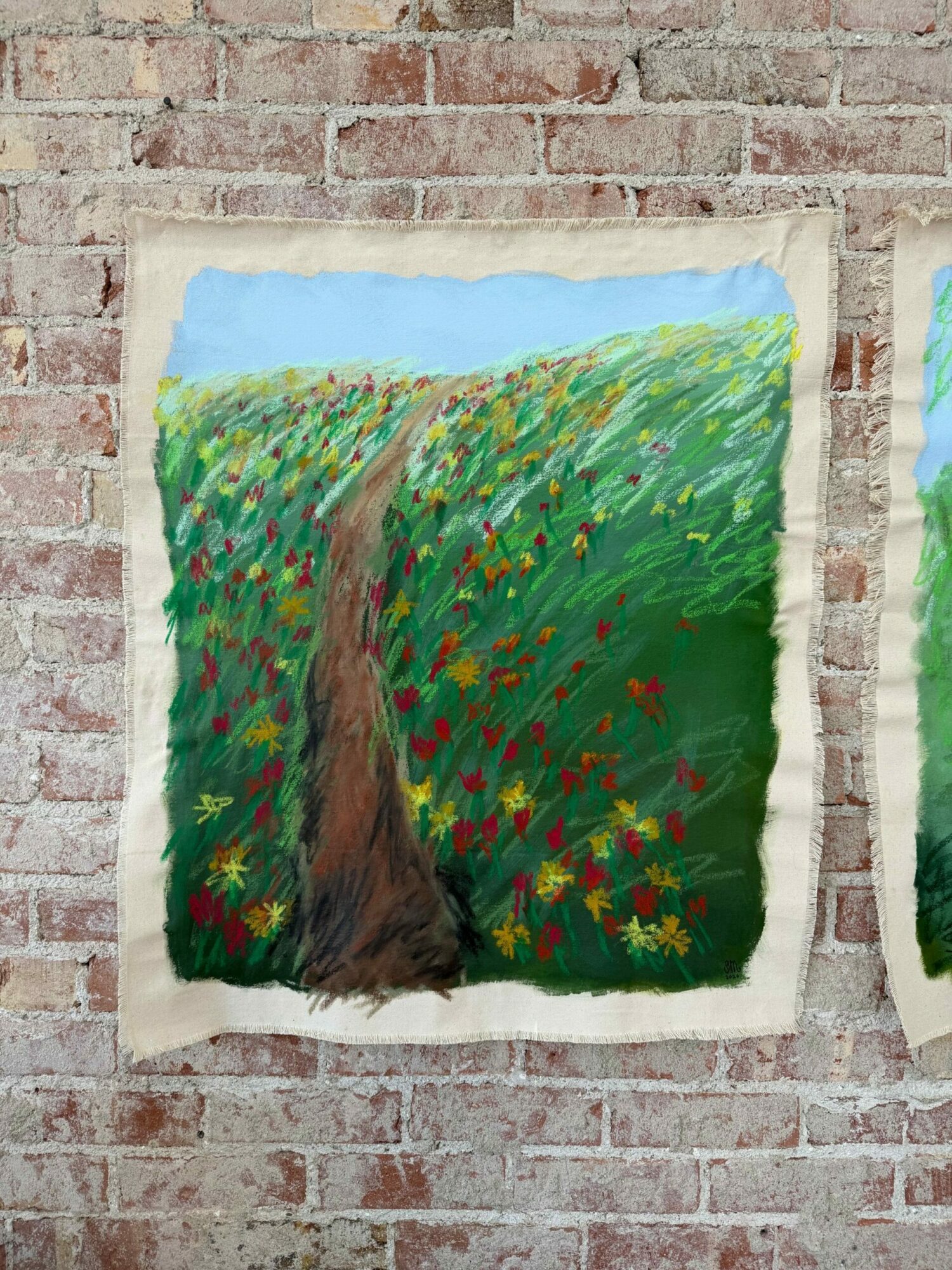 Painting of a green landscape with trees, flowers, and a blue sky, on a textured surface.