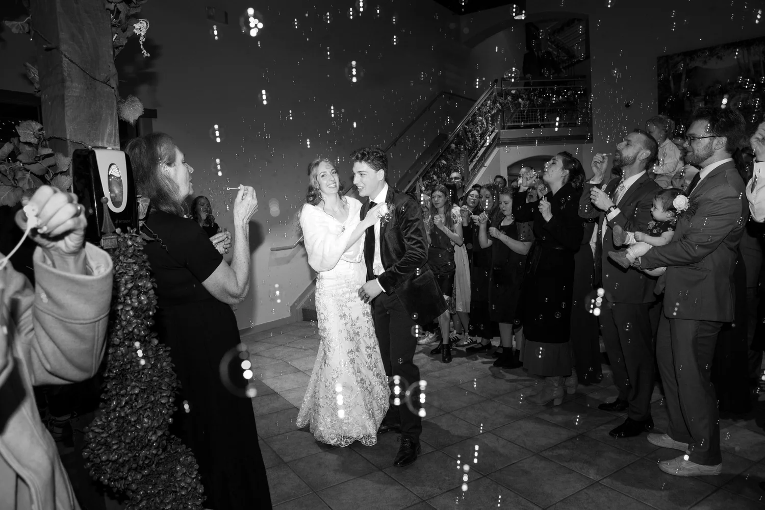 Couple dancing in front of a group of people at a celebration, with confetti falling around them.
