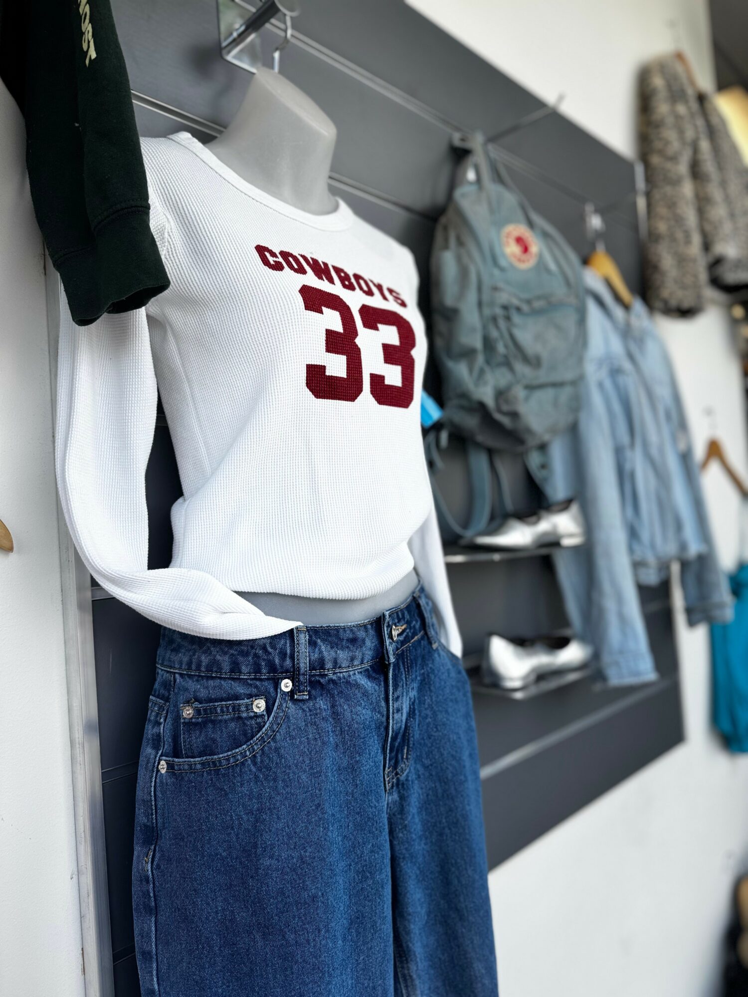 Mannequin dressed in a white Dallas Cowboys jersey with number 33, blue jeans, in a clothing store.