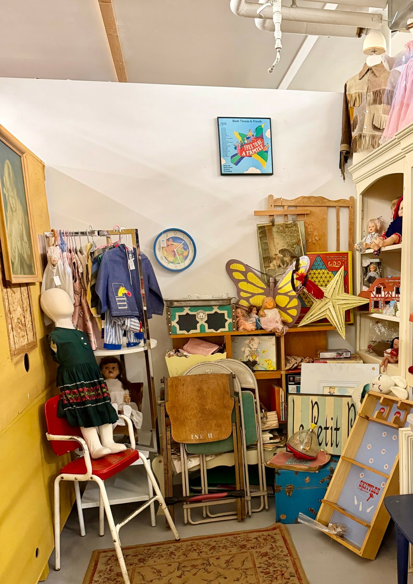 Room filled with children's toys, furniture, and decorations, including chairs, a butterfly, star, and various stuffed animals.