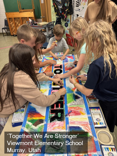 Children gather around a table painting a colorful board game at Viewmont Elementary School in Murray, Utah.