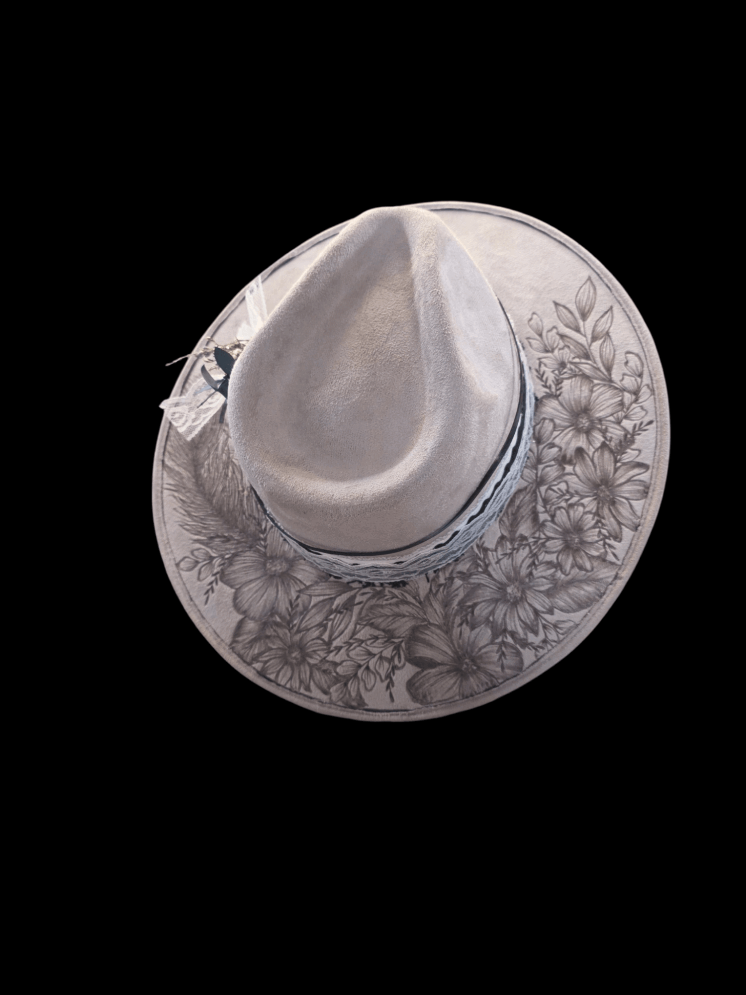 Hat with floral pattern, viewed from above, against a black background.