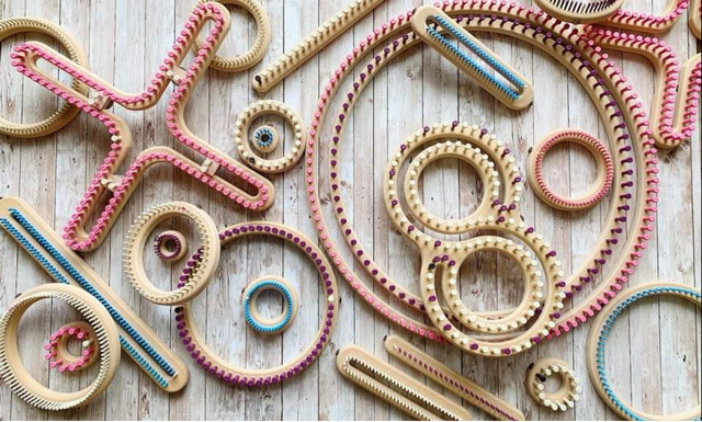 Colorful rubber bands and gears arranged on a wooden surface, forming various shapes and patterns.
