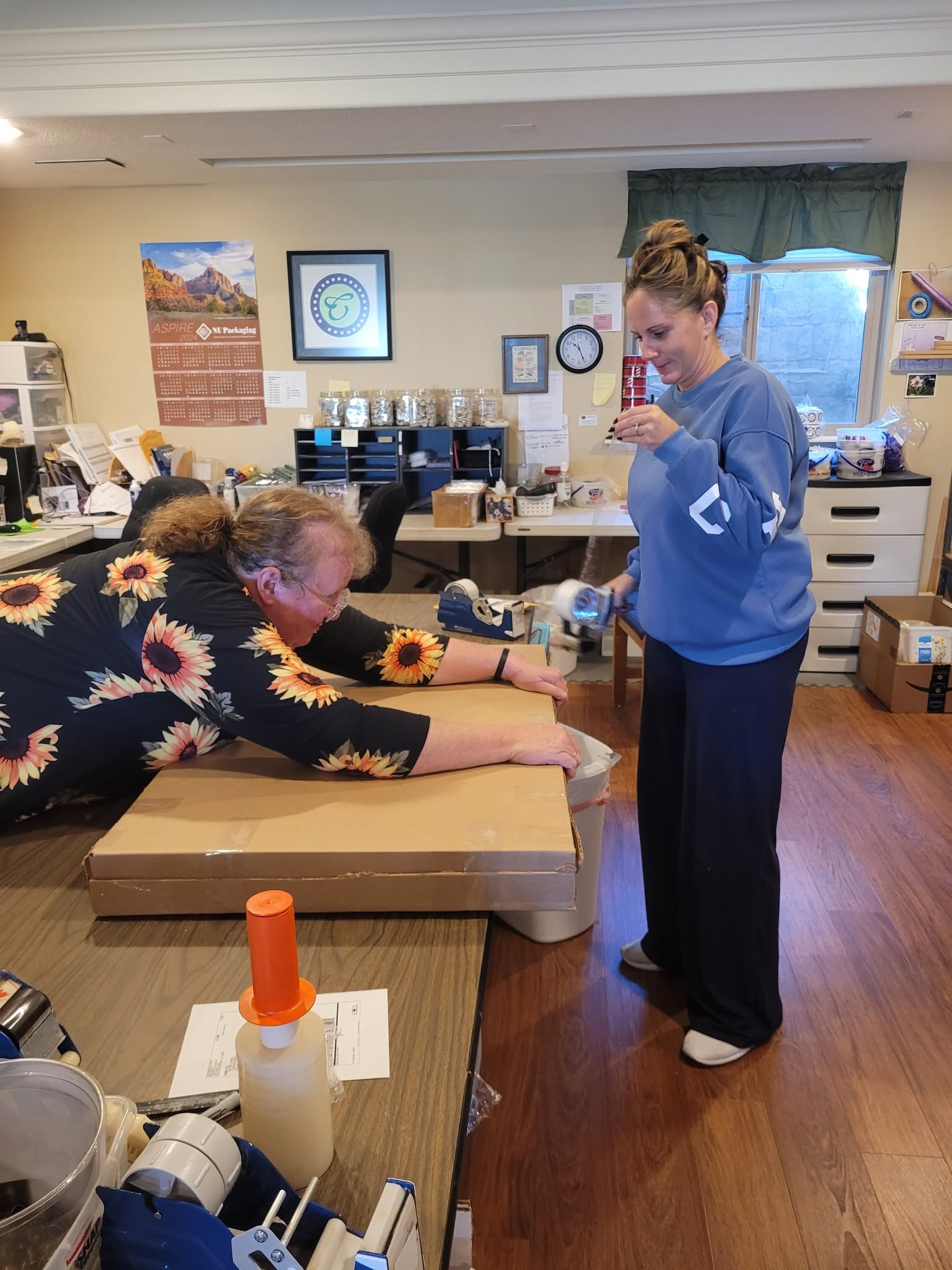 Person lying on table receiving a vaccination from a healthcare worker in a room with office supplies and a window.
