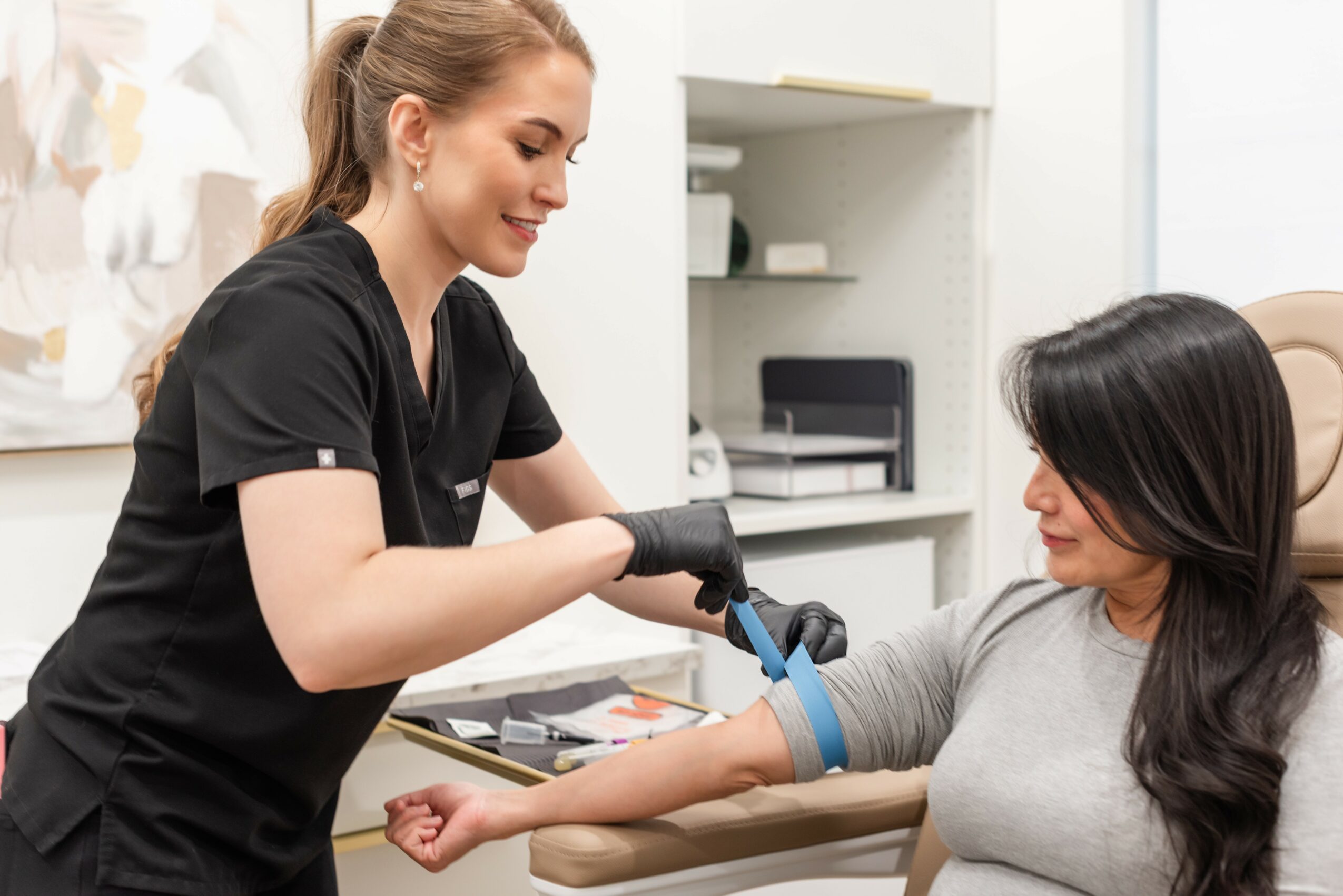 Healthcare professional taking a patient's blood pressure in a clinical setting.