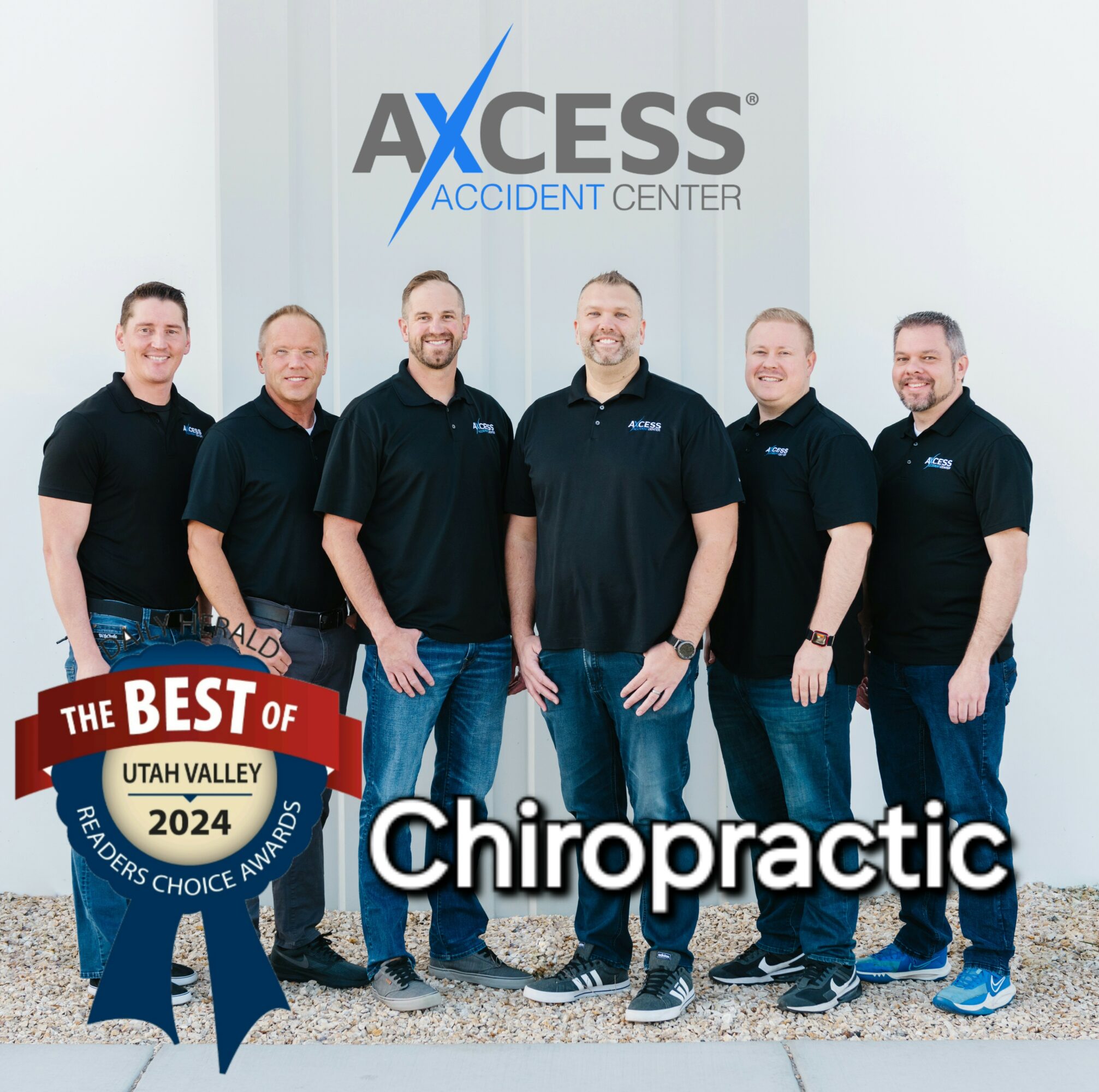 Group of six men standing outside Access Accident Center, smiling, with a chiropractic award badge, in front of a building.