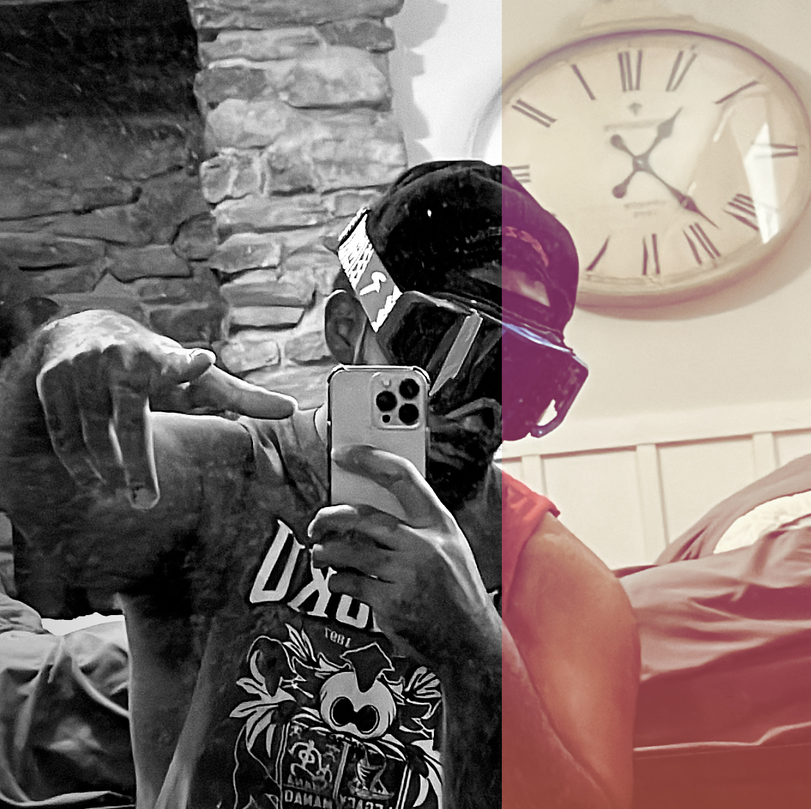 Split-tone mirror selfie of a person holding a phone, with a stone wall and bed beneath a large clock.