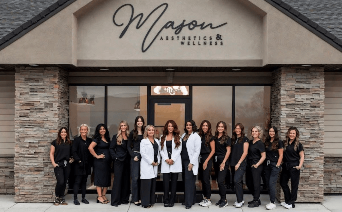 A group of people stands outside a wellness clinic beneath its sign.